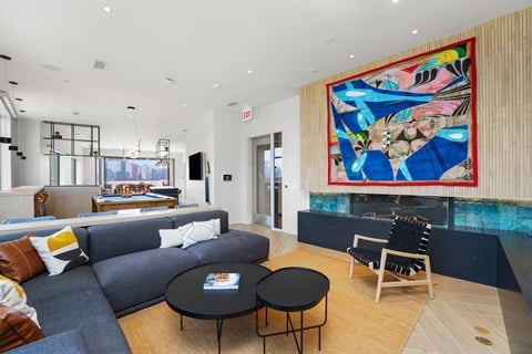a living room with a blue couch and a colorful painting on the wall